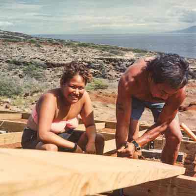 Woman and man working on wooden frame