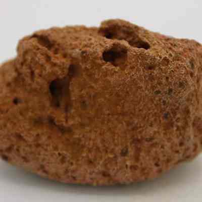 Closeup profile of a small breadloaf sinker: The image shows a roughly textured stone, often used as a traditional sinker in fishing due to its porous nature.