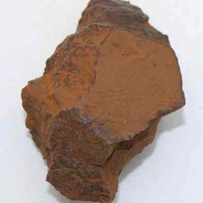 Lengthwise view of adze (ko'i) flake: The image shows a brown, irregularly shaped, stone adze (ko'i) flake with rough, uneven surfaces, hinting at its ancient use and crafting process.