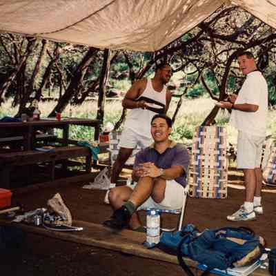 Three men under a shelter