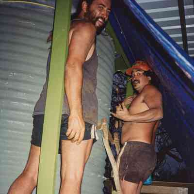 Two men working on water catchment structure