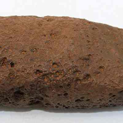 Profile of adze preform: The image shows a brown, irregularly shaped rock with a rough, porous surface texture. The rock appears solid and has an earthy appearance.