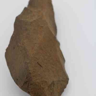 Lengthwise view of adze blank: The image shows a rough, unpolished stone resembling an adze blank, used for crafting tools.