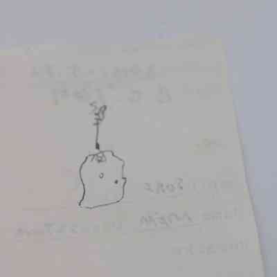 Back of artifact slip (for KIRC Object ID #2015.006.122): The image shows the back of an artifact slip with faint text and a simple hand-drawn sketch of the object.