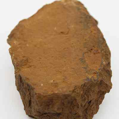 Lengthwise view of a grinding stone: The image shows a rugged, brown grinding stone with an irregular surface, possibly used for traditional milling or sharpening tasks.