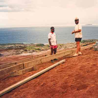 Two men at wooden frame on hardpan