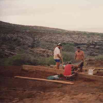Three people pouring concrete