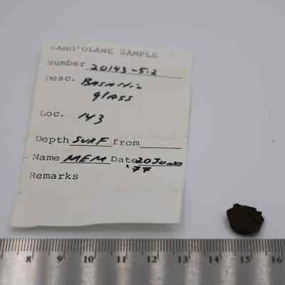 Tiny piece of basaltic glass with ruler and artifact slip