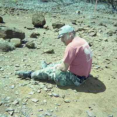 Unidentified man sitting in a potential archaeological site