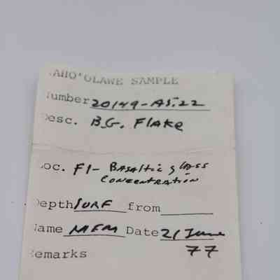 Artifact slip for basaltic glass flake: The image shows an artifact slip with details about a basaltic glass flake sample, including location, depth, and date.