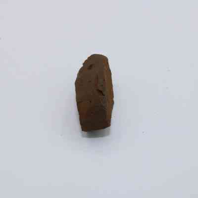 Edge of basaltic glass piece: A single piece of brown basaltic glass with a rough, uneven texture sits against a plain white background.