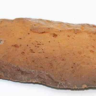 Basalt knife (pahi) with alternate id number visible: This image shows an ancient stone knife (pahi) with a roughly shaped blade, likely used for cutting or scraping, resting on a white background.