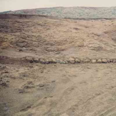 Row of stones along an edge of dirt trail/road