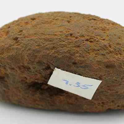 Closeup profile of breadloaf sinker with visible alternate id number: The image shows a brown, rough-surfaced rock with a white label marked "9.35," placed against a plain white background.
