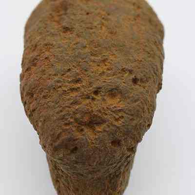 Closeup of lengthwise view of breadloaf sinker: The image shows a rusted, roughly textured, brownish object resembling a bread loaf viewed from above against a plain white background.