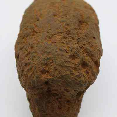 Closeup lengthwise view of breadloaf sinker: The image shows a close-up of a brown rock with a rough, textured surface against a plain white background.