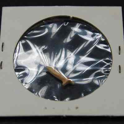 Closeup of portion of fishhook: The image shows a small part of a fishhook displayed inside a clear plastic-covered paper slide, secured neatly.