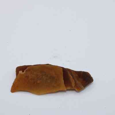 A piece of calcite: The image features a brownish calcite mineral piece, displaying layered formations on a plain white surface.