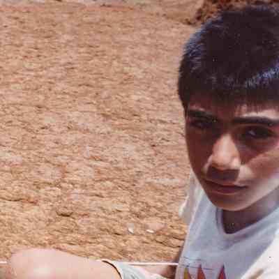 Young person kneeling on hardpan
