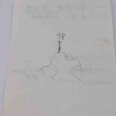 Back of artifact slip for a basaltic glass flake (KIRC Object ID# 2015.006.99): The image shows a piece of paper with a hand-drawn diagram and some faint text, featuring an arrow pointing to a specific point labeled "SP."