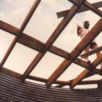 Man waving while on top of wooden grid