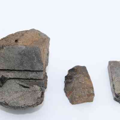 Closeup of basaltic glass core with pieces: The image shows three pieces of basaltic glass core, with distinctive textures and color variations.