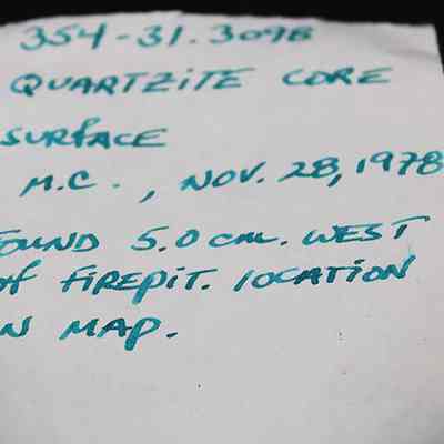 Artifact slip for quartzite core: The image shows a handwritten note with details about a quartzite core surface found on November 28, 1978, approximately 5.0 centimeters west of a firepit.