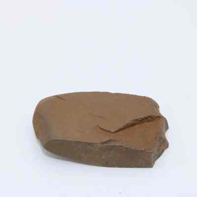 Closeup of polished flake: The image shows a polished flake of stone with smooth surfaces and visible textures, indicating careful shaping and refinement, against a plain background.