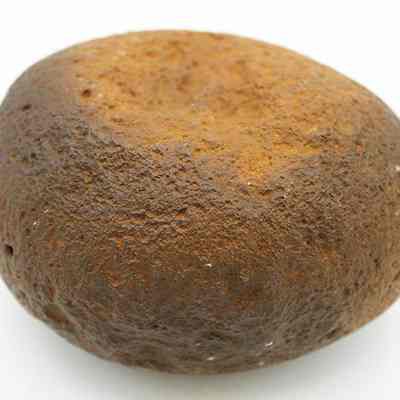 Profile of a basalt hammerstone: The image depicts a hammerstone, an ancient tool used for striking, featuring a rounded shape and a rough, textured surface in earthy brown hues.