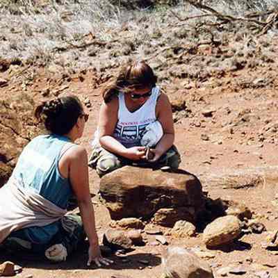 Two women sitting in a possible archaeological site