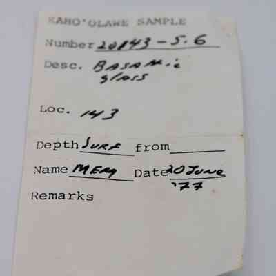 Artifact slip for basaltic glass flake: The image shows a sample label from Kaho'olawe, describing basaltic glass, with details like location Site 143, recorded by MEM on 20 June1977.