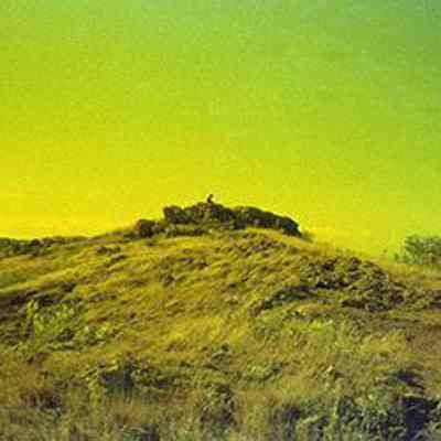 Distant view of a person sitting on a rock outcrop