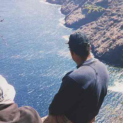 Two people sitting on cliff