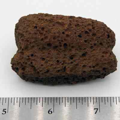 Profile of breadloaf sinker: The image shows a textured, brownish breadloaf sinker with a porous surface, positioned above a measuring scale.