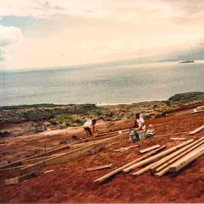 Two men working on wooden form on hardpan