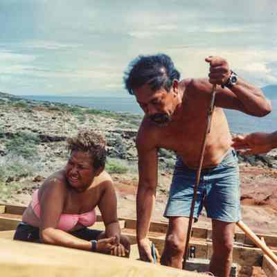 Woman and man working on wooden frame
