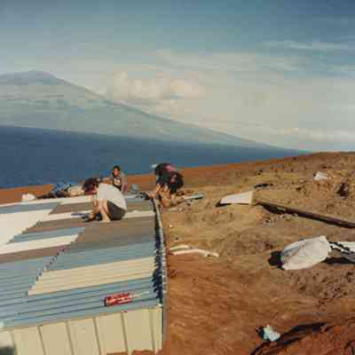 People working on a metal water catchment structure
