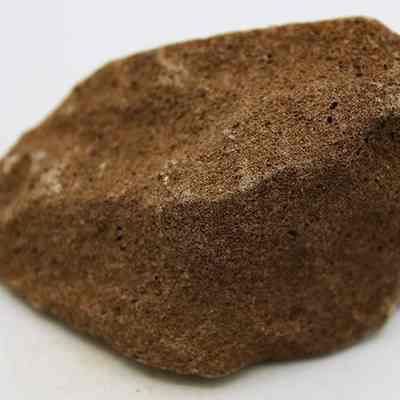 Profile of pumice file: The image shows a textured brown pumice stone with small pores, placed on a plain background.