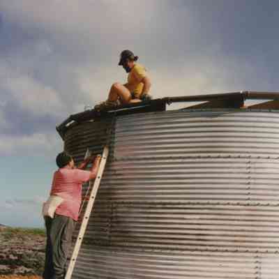 Two men working on water tank