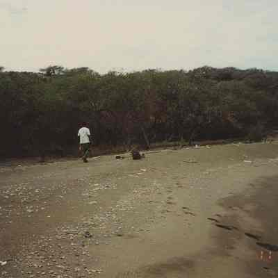 Man walking along Hiuula Beach