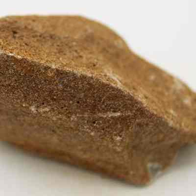 Profile of pumice file: The image shows a brown pumice stone with a rough, porous texture.