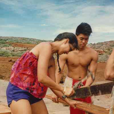 Two people working on wooden frame