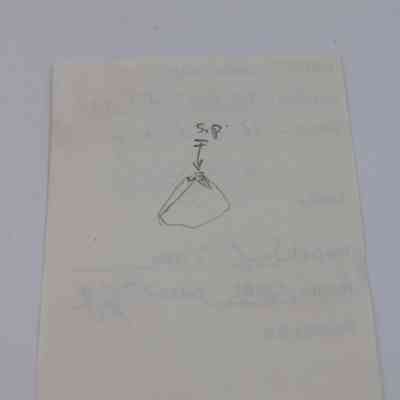 Sketch on back of artifact slip for basaltic glass flake: The image shows a simple hand-drawn sketch on paper of a triangular shape labeled with "S.P." and an arrow pointing downward.