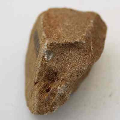 Lengthwise view of pumice file: The image shows a pumice stone with a rough, textured surface, lying on a plain background.