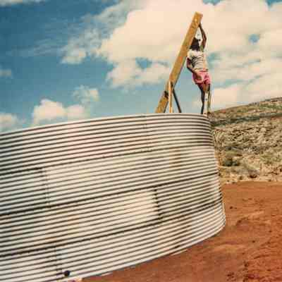 Man standing on ladder at water catchment
