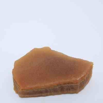 Agate flake: The image shows an agate flake with layered patterns in shades of brown on a plain, white background.
