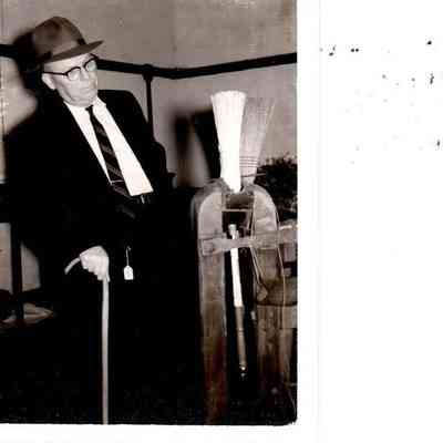Siney Lovelace observes a Shaker made broom. (1961)