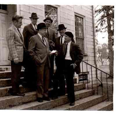 Standing on the steps of the Center Family House are Charles H. Sturgill and Burwell K. Marshall (at right) are handing the papers for the purchase of Shaker Hill. Watching (L to R) are Gene Royalty, Earl D. Wallace, Hilary Boone, and Robert Jewell (1962)