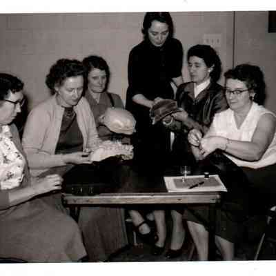 Homemakers making Easter bonnets. Pictured (L to R) Mrs. David Brown, Mrs. William Wright, Mrs. Leon Conder, Mrs. O.W. Brogli and Mrs. John Dismuke. Standing is Fern Luttrell