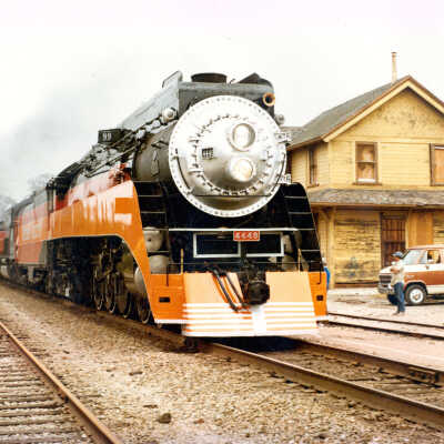 Color photograph of 4449 Daylight train passing closed Goleta Depot
